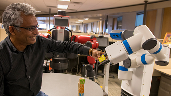 Professor Kambhampati interacts with blocks and a robotic arm